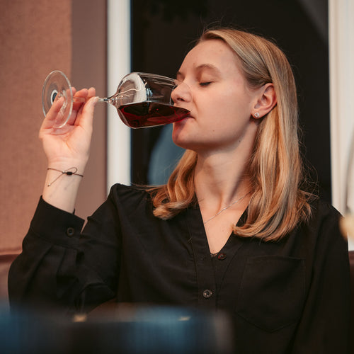 Frau verkostet Rotwein aus dem Weinangebot der WZG.