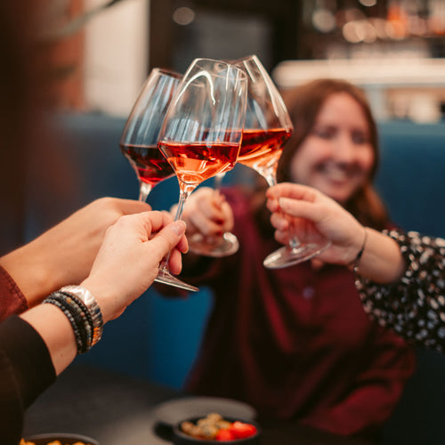 Gesellige Runde beim Anstoßen mit Rotwein aus dem Sortiment der WZG Weine.