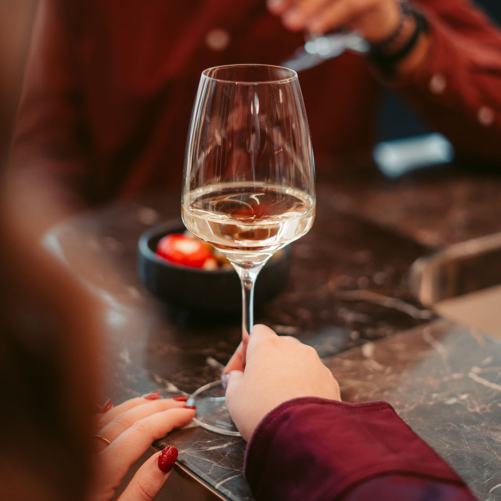 Zwei Personen stoßen bei einem gemütlichen Abend mit Roséwein aus dem Sortiment der WZG an.