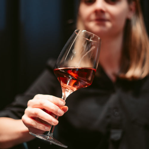 Frau genießt Rotwein aus dem Weinangebot der WZG in entspannter Atmosphäre.