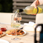 Edition Gourmet Chardonnay wird beim Grillen in ein Glas eingeschenkt