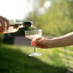 Roséwein wird bei einer Party in ein Glas eingeschenkt im Freien