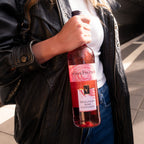 Person hält eine Flasche Süss & Fruchtig Roséwein der WZG in der Hand.